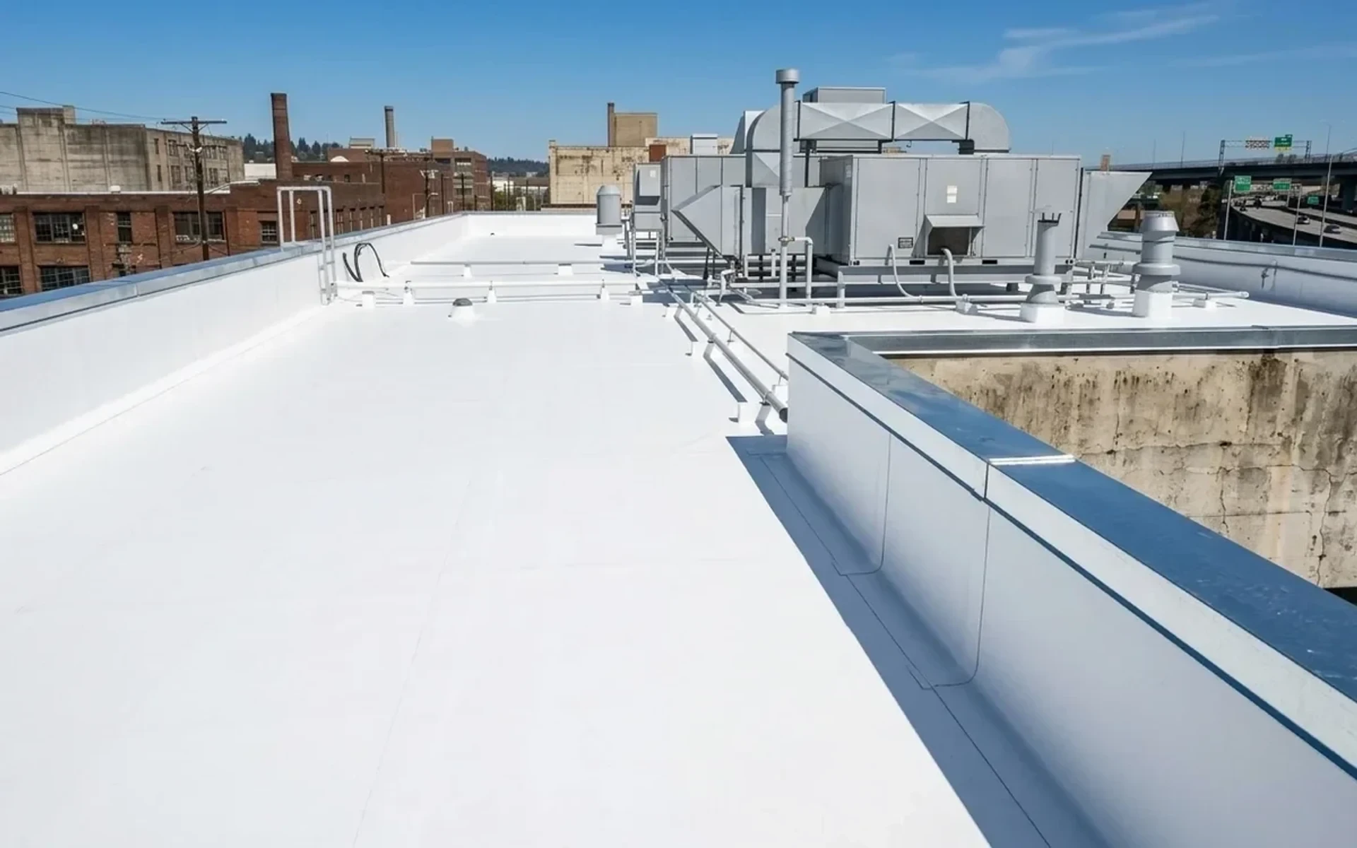 After: Brand new commercial 60-mil TPO flat roof with robotic heat-welded seams and crisp parapet metal coping